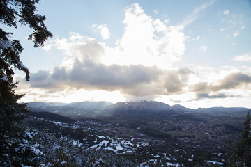 Landscape of a snowy valley with a village and mountains in the background
