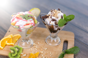 Fresh ice cream witn chocolate and fruits on wooden plate