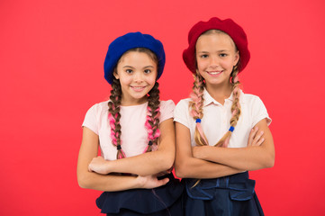 Stylish and confident. Cute girls having the same hairstyle. French style girls. Small children with long hair plaits. Fashion girls with tied hair into braids. Little kids wearing french berets