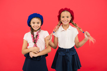 Cute and stylish. Little kids wearing stylish french berets. French style girls. Cute girls having the same hairstyle. Small children with long hair plaits. Fashion girls with tied hair into braids