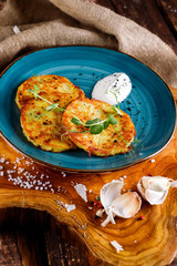 Close-up view of potato pancakes. Potato cake on a blue plate on a wooden table
