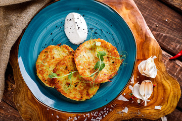 Close-up view of potato pancakes. Potato cake on a blue plate on a wooden table