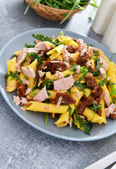 Penne pasta with tuna chunks, rucola and dry tomatoes