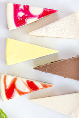 Slices of various cheese cakes on white plate. Sugar desserts, food concept 