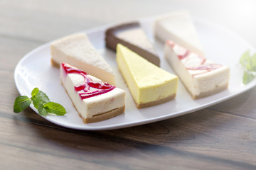 Slices of various cheese cakes on white plate. Sugar desserts, food concept 