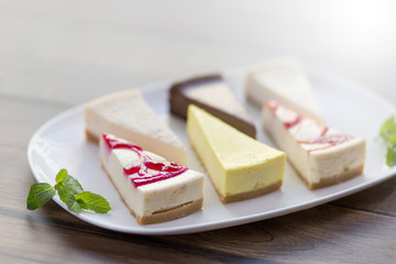 Slices of various cheese cakes on white plate. Sugar desserts, food concept 