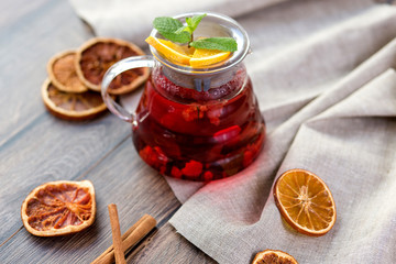 Citrus vitamin natural organic hot tea with berries and citrus fruits in glass spot with cups