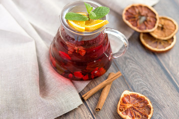 Citrus vitamin natural organic hot tea with berries and citrus fruits in glass spot with cups