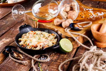 Tasty seafood in white sauce on a metal black plate.