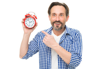 Please observe time. Mature man pointing finger at alarm clock. Mature timekeeper with analog...