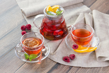 Citrus vitamin natural organic hot tea with berries and citrus fruits in glass spot with cups