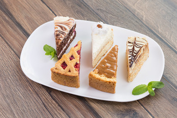 Slices of various cheese cakes on white plate. Sugar desserts, food concept 