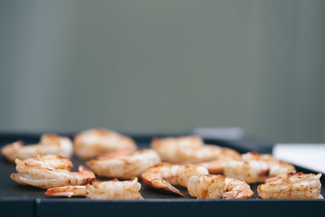 Cook prepares grilled shrimps