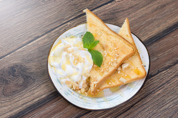 Tasty sandwich with cream, nuts and honey on wooden background
