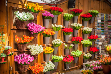 Colorful tulips bouquets arrangements at the wall in plastic cans at flower market in Amsterdam