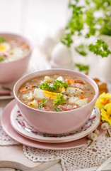 Bowl of sour soup, (Żurek), polish Easter soup with the addition of sausage, hard boiled egg and vegetables in a ceramic bowl. Traditional Easter dish in Poland
