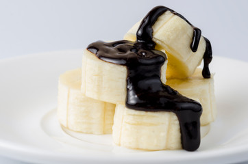 Sliced ​​bananas in chocolate icing on a light background