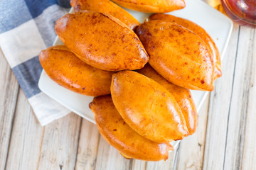 Delicious tasty pies on plate at home in kitchen. Homemade food concept