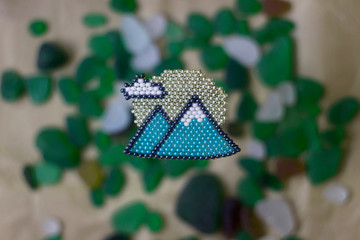 Bead brooch in the form of mountains, original gift to the tourist, crafting background