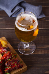 Beer and pork spare ribs with fry. Beer and meat. Glass of ale. vertical