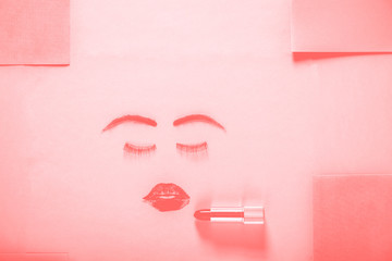 Creative woman face made of eyelashes, wig eyebrows and red lipstick stains as lips.