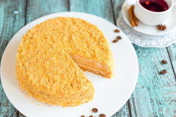 Honey cake on white plate on wooden table. Picture for a menu or a confectionery catalog