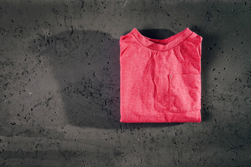 Top view of a children's red blouse, shirt and on stone background. The concept of children's clothes, online shop.