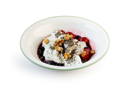 Healthy breakfast of yorgurt, fruit, walnuts and chia seeds on white