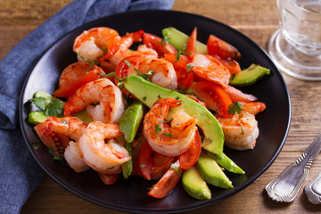 Shrimp, Avocado, Tomato and Cilantro Salad. Grilled prawns on black plate