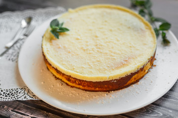 Cheese cake on white plate with mint. Sugar dessert, photo for menu