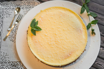 Cheese cake on white plate with mint. Sugar dessert, photo for menu