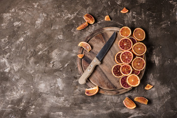 Sliced Blood oranges fruits with knife over old dark wooden background