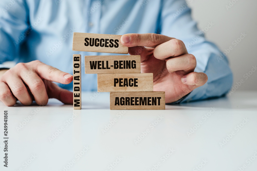 Poster the role of the mediator in maintaining stability in life. man arranges wooden blocks with inscripti