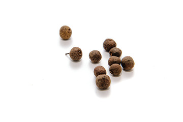 Allspice on a light, white background. Seeds of herbal medicine located on a white background. The concept of spices and adding spices to eat.