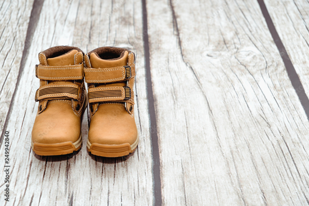 Wall mural a pair of small leather shoe isolated on a light, childish blue background. warm, fur-lined children