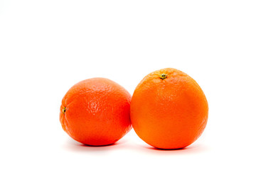 Two fresh oranges isolated on a white background. Delicious oranges lie on the table. The concept of providing vitamins along with fruits. Eating fruit on a daily basis.