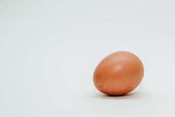 Egg isolated on white. Using an egg for preparing an omelette, scrambled eggs. Chicken egg lies on a white table.