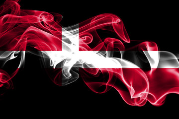 National flag of Denmark made from colored smoke isolated on black background. Abstract silky wave background.