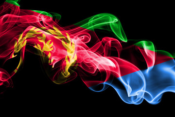 National flag of Eritrea made from colored smoke isolated on black background. Abstract silky wave background.