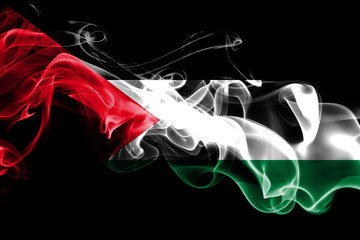 National flag of Palestine made from colored smoke isolated on black background. Abstract silky wave background.