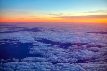 flying above clouds at the sunset 
