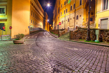 Fototapeta na wymiar night street in Rome and cobblestone pedestrian road