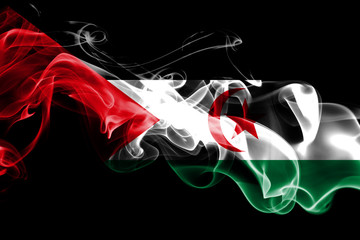 National flag of Sahrawi made from colored smoke isolated on black background. Abstract silky wave background.