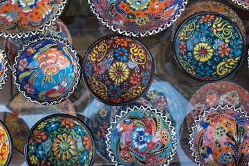 Colorful pottery souvenir bowls on glass shelf for sale, Bulgaria