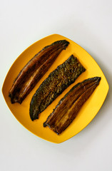 Eel fish or unagi on yellow plate with white background. Ready to cook. 