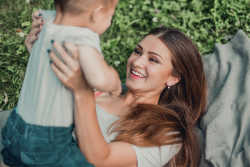 Fototapeta premium Mother with little son spend time together in green park.
