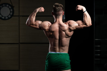Obraz na płótnie Canvas Bodybuilder Performing Rear Double Biceps Pose