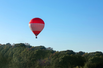 Beautiful view of hot air balloon flying over autumn forest. Space for text