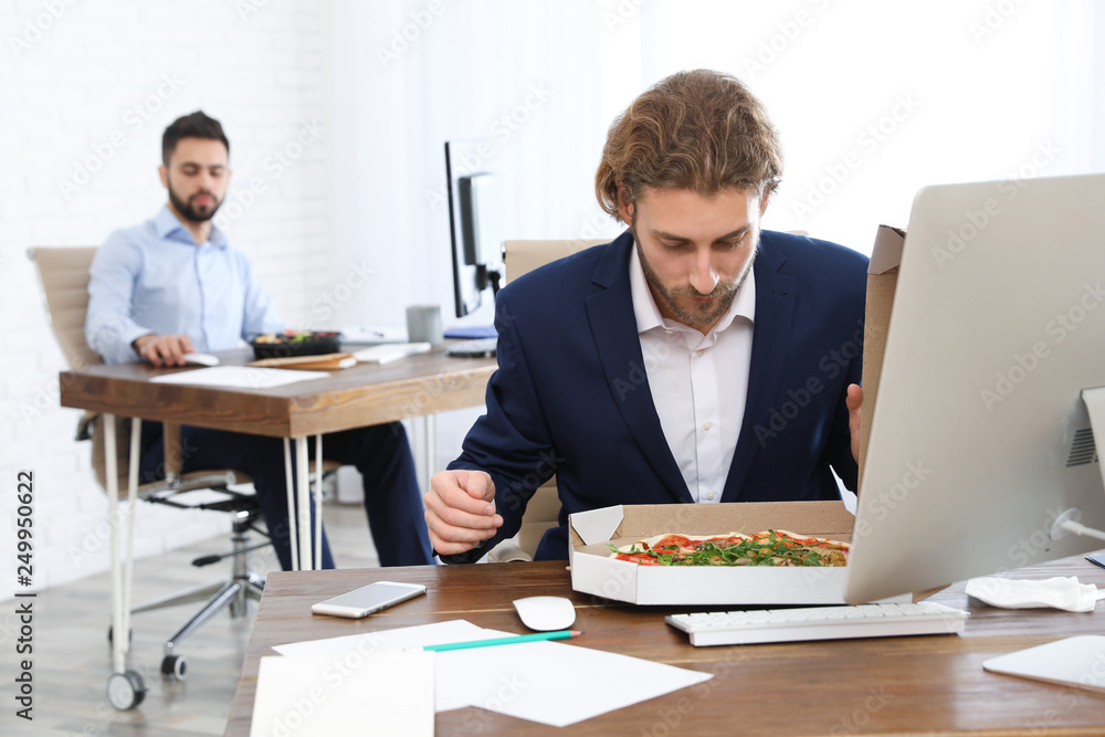 Canvas Prints Office employee having pizza for lunch at workplace. Food delivery