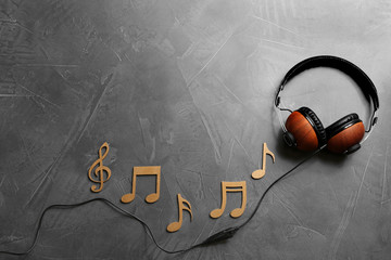 Flat lay composition with music notes, headphones and space for text on grey background